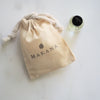 Makaka Perfume on white next to a muslin pouch with the name Makana stamped on it